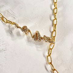 A detailed image of a gold-plated brass paper clip chain necklace with a 3D calligraphic dragon pendant on the right side, displayed on a textured white background.